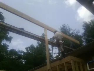 Carpenter setting a ridge beam over a new addition frame — Ice Dam Removal by Roofing Brothers in Bellvue