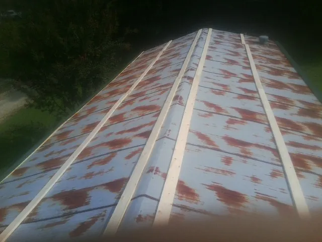 Rusted metal roof panels with new wood purlins before replacement — Storm Damage Roof Repair in Bellvue by Roofing Brothers
