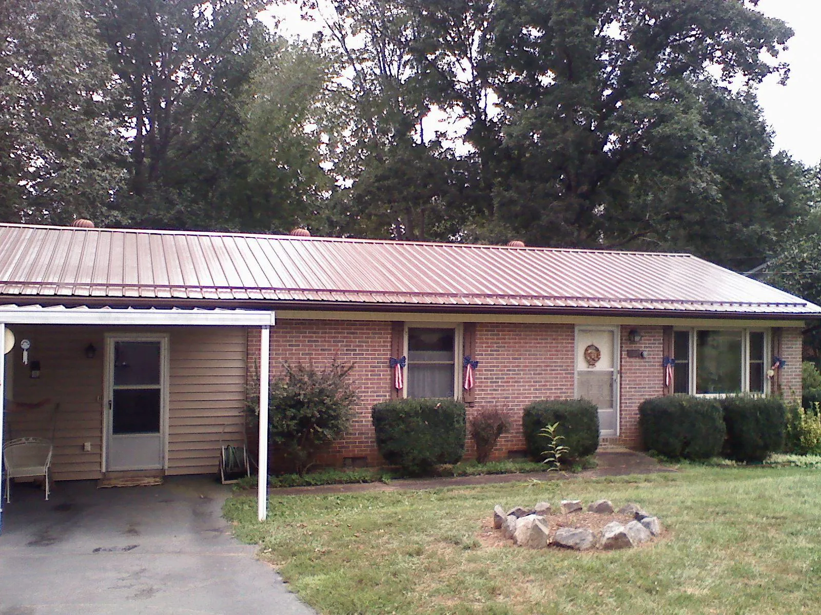 Bronze metal roof and carport on a brick ranch home — Roof Repair work by our crew in Bellvue